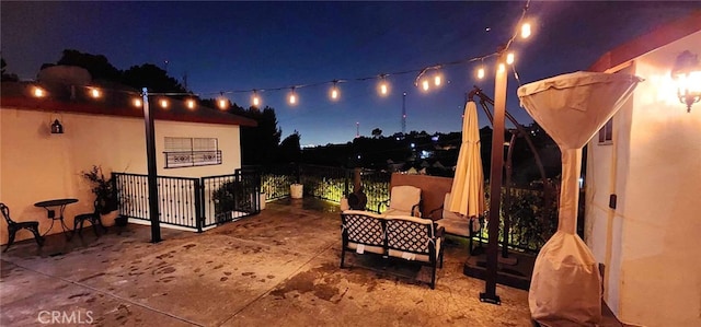 patio at night featuring a water view