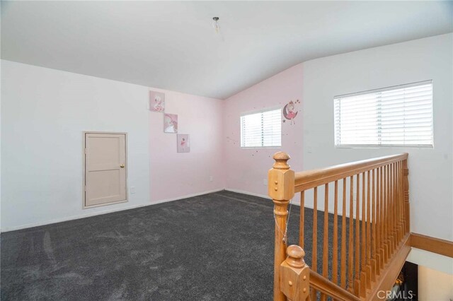 carpeted spare room featuring lofted ceiling