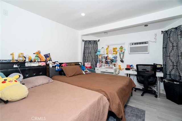 bedroom featuring light wood-type flooring and a wall mounted AC