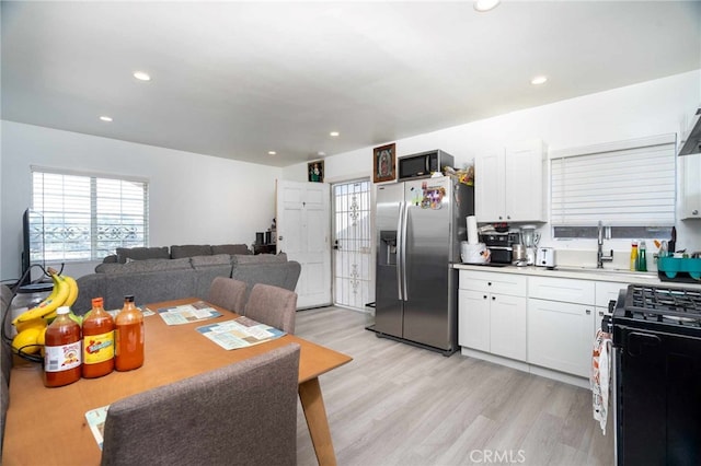 kitchen featuring white cabinets, sink, light hardwood / wood-style floors, and black appliances