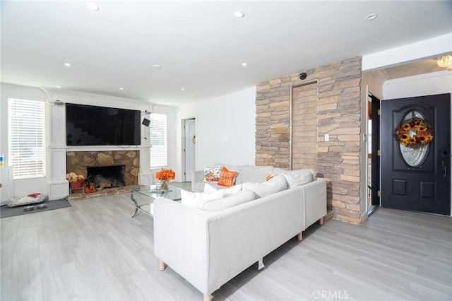 living room featuring light hardwood / wood-style floors and a stone fireplace