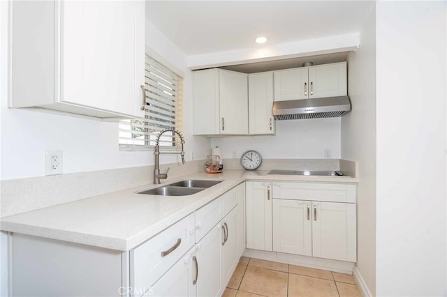 kitchen featuring electric cooktop, light tile patterned flooring, white cabinetry, and sink