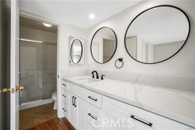 bathroom featuring vanity, toilet, and walk in shower