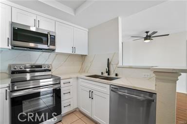 kitchen featuring decorative backsplash, white cabinetry, sink, and stainless steel appliances