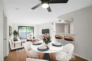 dining space with wood-type flooring and ceiling fan