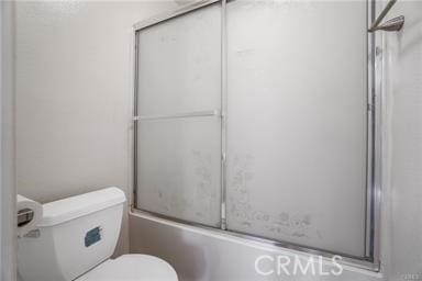 bathroom with toilet and enclosed tub / shower combo