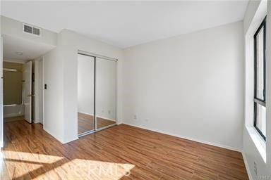 unfurnished bedroom featuring a closet and hardwood / wood-style floors