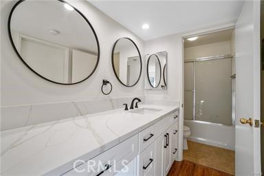 full bathroom with hardwood / wood-style floors, vanity, toilet, and shower / tub combination