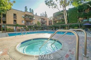 view of swimming pool featuring a community hot tub