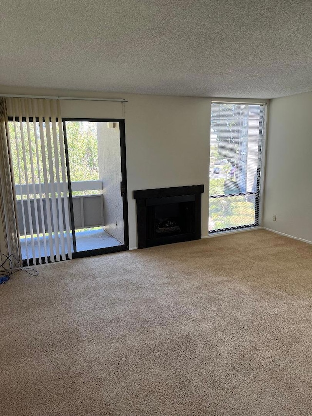 unfurnished living room with a textured ceiling and carpet flooring