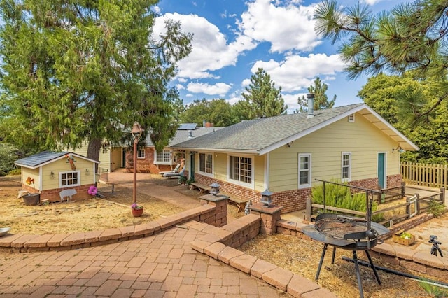 back of property featuring a patio area and an outbuilding