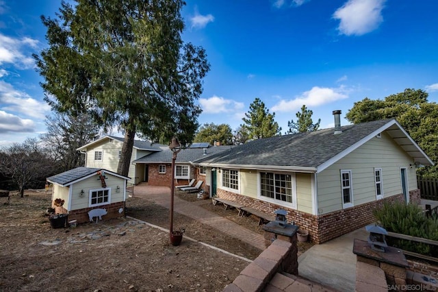 view of front of house with a patio and a storage unit