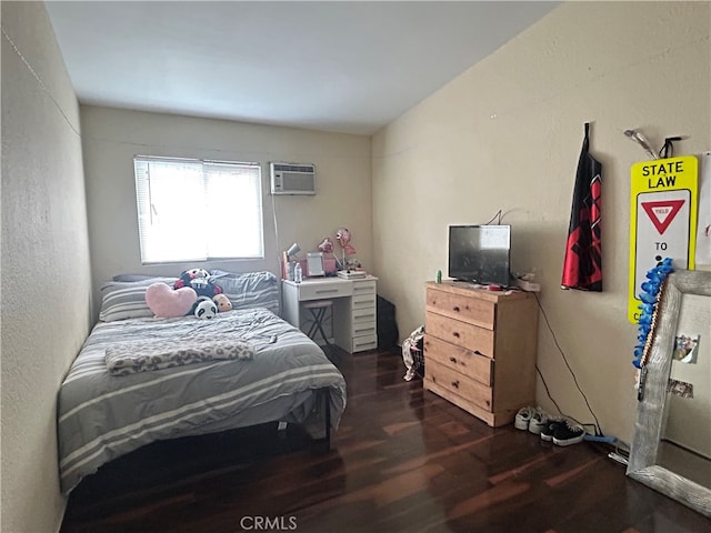 bedroom featuring dark wood-type flooring and an AC wall unit