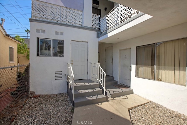 view of exterior entry featuring a balcony