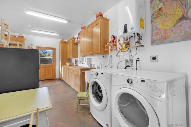 laundry room featuring cabinets, water heater, and washer and dryer