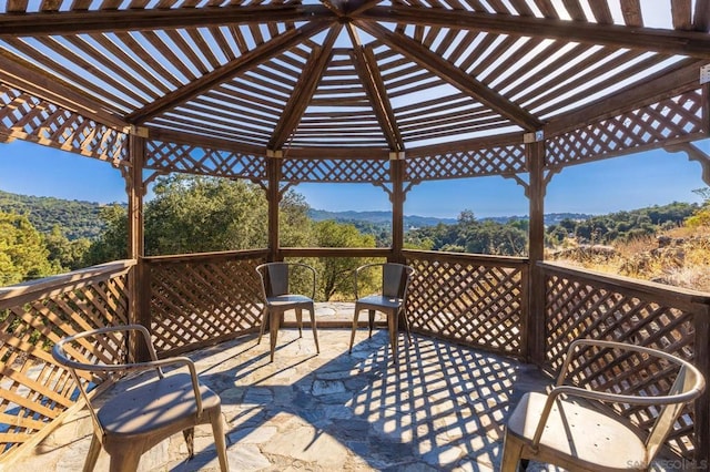 wooden deck featuring a pergola and a patio