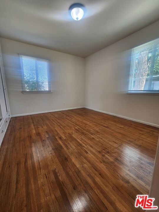 unfurnished room with a healthy amount of sunlight and dark hardwood / wood-style floors