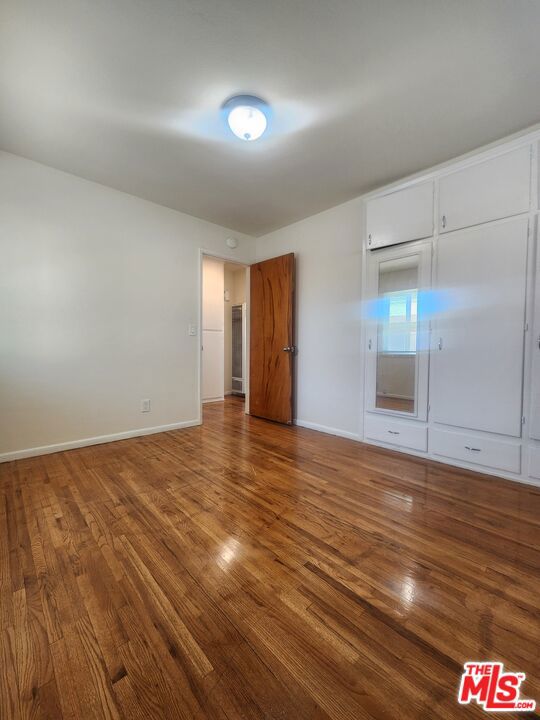 unfurnished bedroom featuring hardwood / wood-style floors and a closet