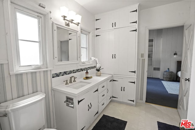 bathroom featuring backsplash, vanity, and toilet