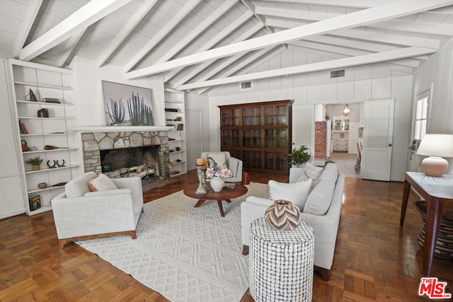 living room featuring a stone fireplace, vaulted ceiling with beams, and dark parquet floors