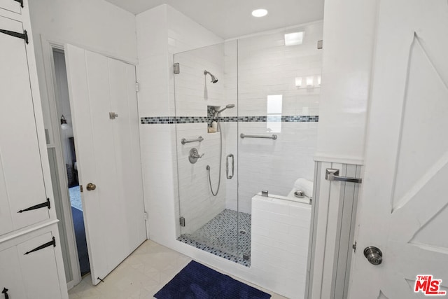 bathroom featuring a shower with door