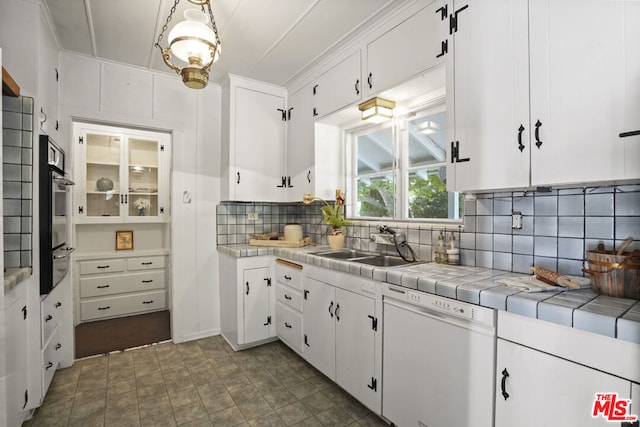 kitchen featuring decorative backsplash, white cabinetry, dishwasher, and tile countertops