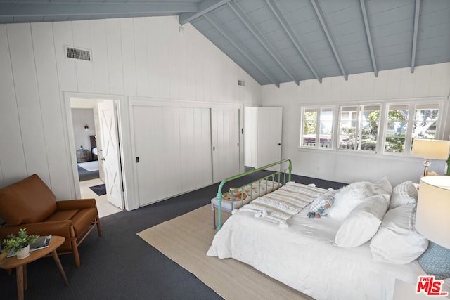 bedroom featuring high vaulted ceiling and beam ceiling