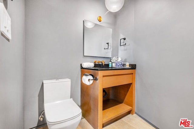 bathroom featuring vanity, hardwood / wood-style floors, and toilet