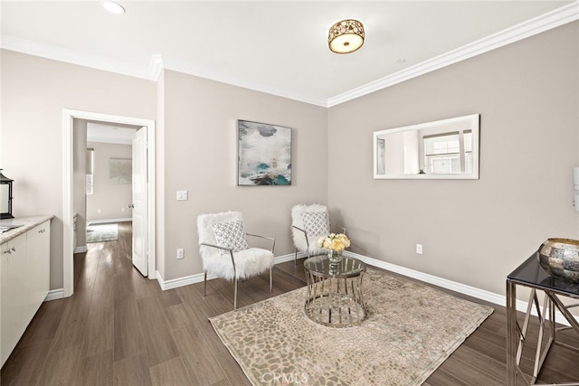 sitting room with dark wood-type flooring and ornamental molding