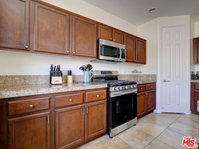 kitchen with light tile patterned flooring and stainless steel appliances