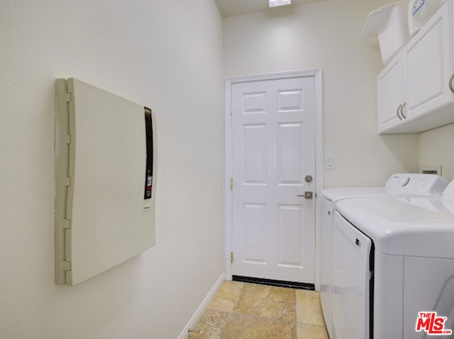 washroom with cabinets and washing machine and clothes dryer