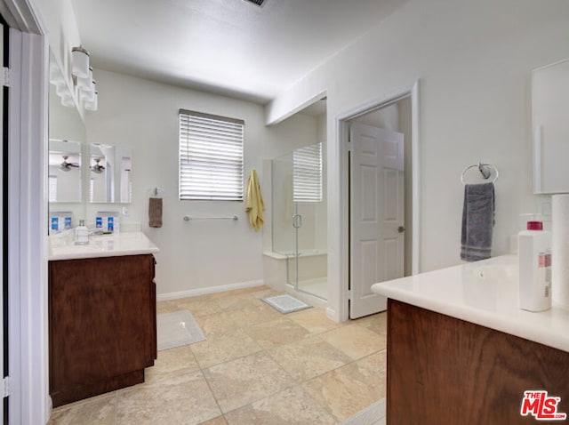 bathroom with vanity and a shower with door