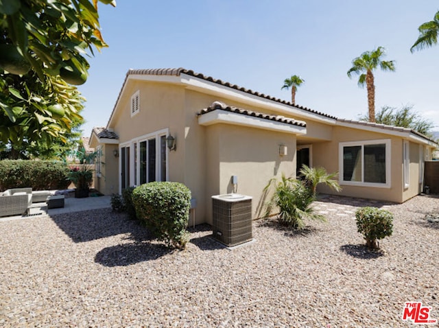 rear view of property featuring a patio and central air condition unit