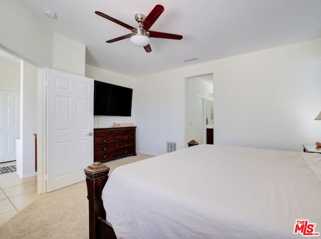 bedroom with connected bathroom, ceiling fan, and light colored carpet