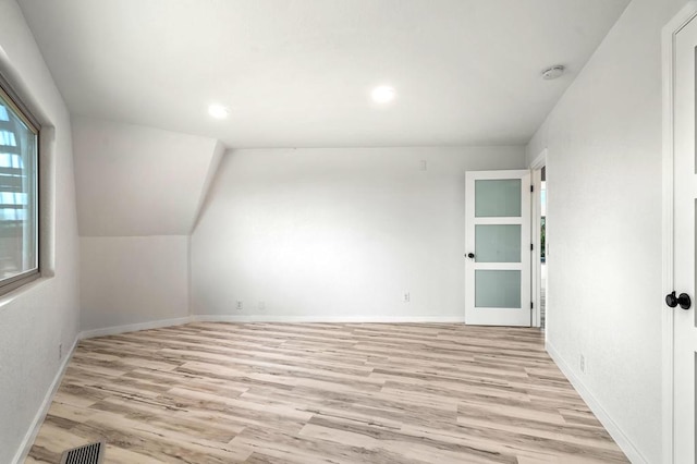 interior space with light wood-type flooring and lofted ceiling