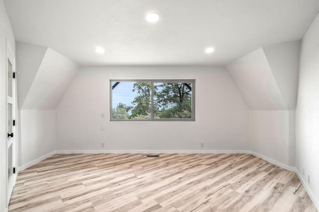 bonus room featuring vaulted ceiling and light wood-type flooring