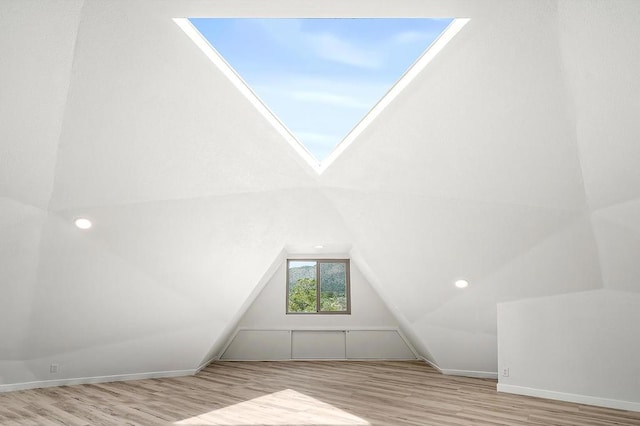 bonus room featuring light hardwood / wood-style flooring and vaulted ceiling with skylight