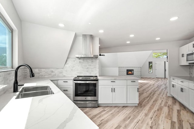 kitchen with white cabinets, wall chimney exhaust hood, and stainless steel appliances