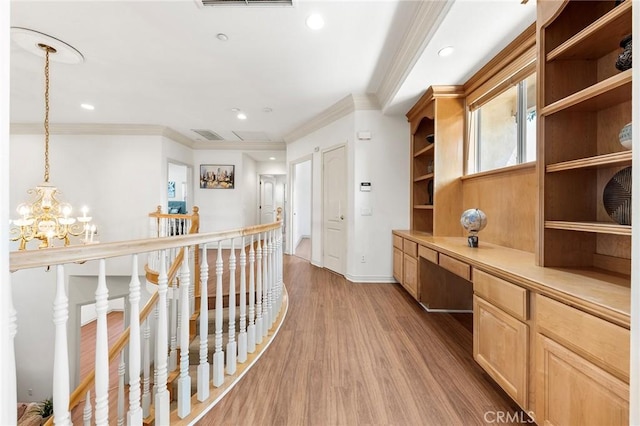 corridor featuring a chandelier, hardwood / wood-style floors, and crown molding