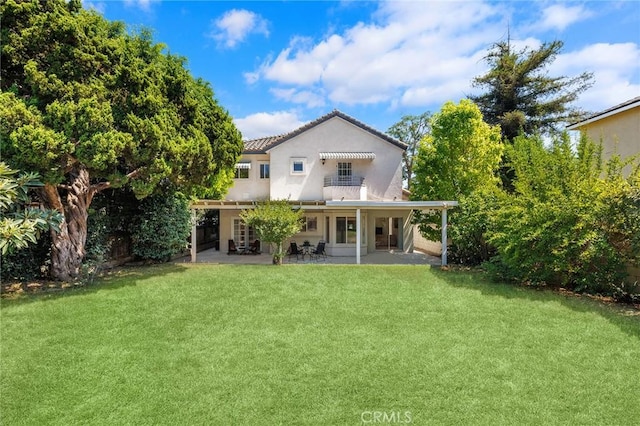 back of property featuring a lawn and a patio