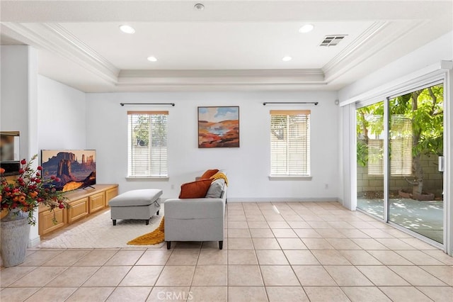 living area featuring ornamental molding, light tile patterned floors, and a tray ceiling