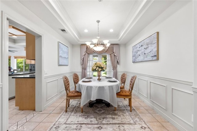 tiled dining area featuring a tray ceiling, crown molding, plenty of natural light, and an inviting chandelier