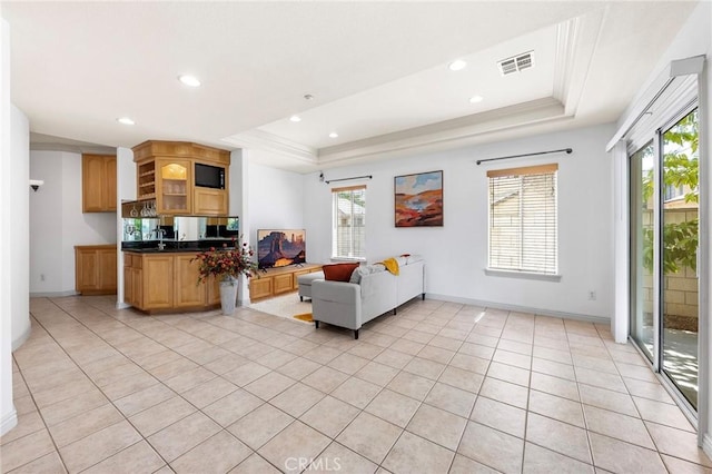 living room featuring a raised ceiling, a wealth of natural light, and light tile patterned flooring