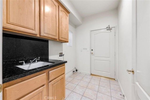 clothes washing area with cabinets, light tile patterned floors, sink, and hookup for a washing machine