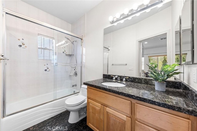 full bathroom featuring vanity, toilet, and enclosed tub / shower combo