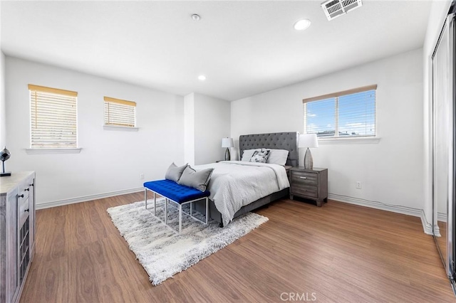 bedroom featuring multiple windows and hardwood / wood-style floors