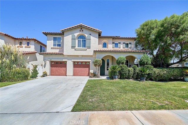 mediterranean / spanish-style home featuring a front yard and a garage