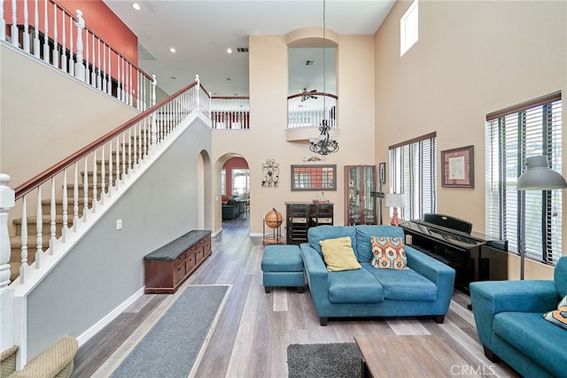 living room with a notable chandelier, a high ceiling, and hardwood / wood-style flooring