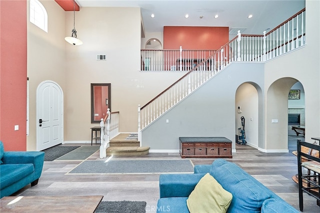 living room with a towering ceiling and dark hardwood / wood-style floors