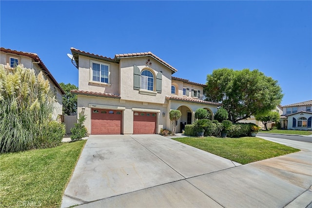 mediterranean / spanish home featuring a front lawn and a garage